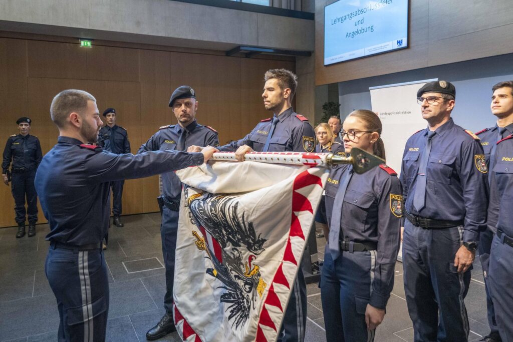 Eine Aspirantin und zwei Aspiranten leisteten stellvertretend für die drei neu in die Polizeiausbildung

aufgenommenen Grundausbildungskurse den Angelobungsschwur an der Fahne der LPD Tirol © Polizei Tirol