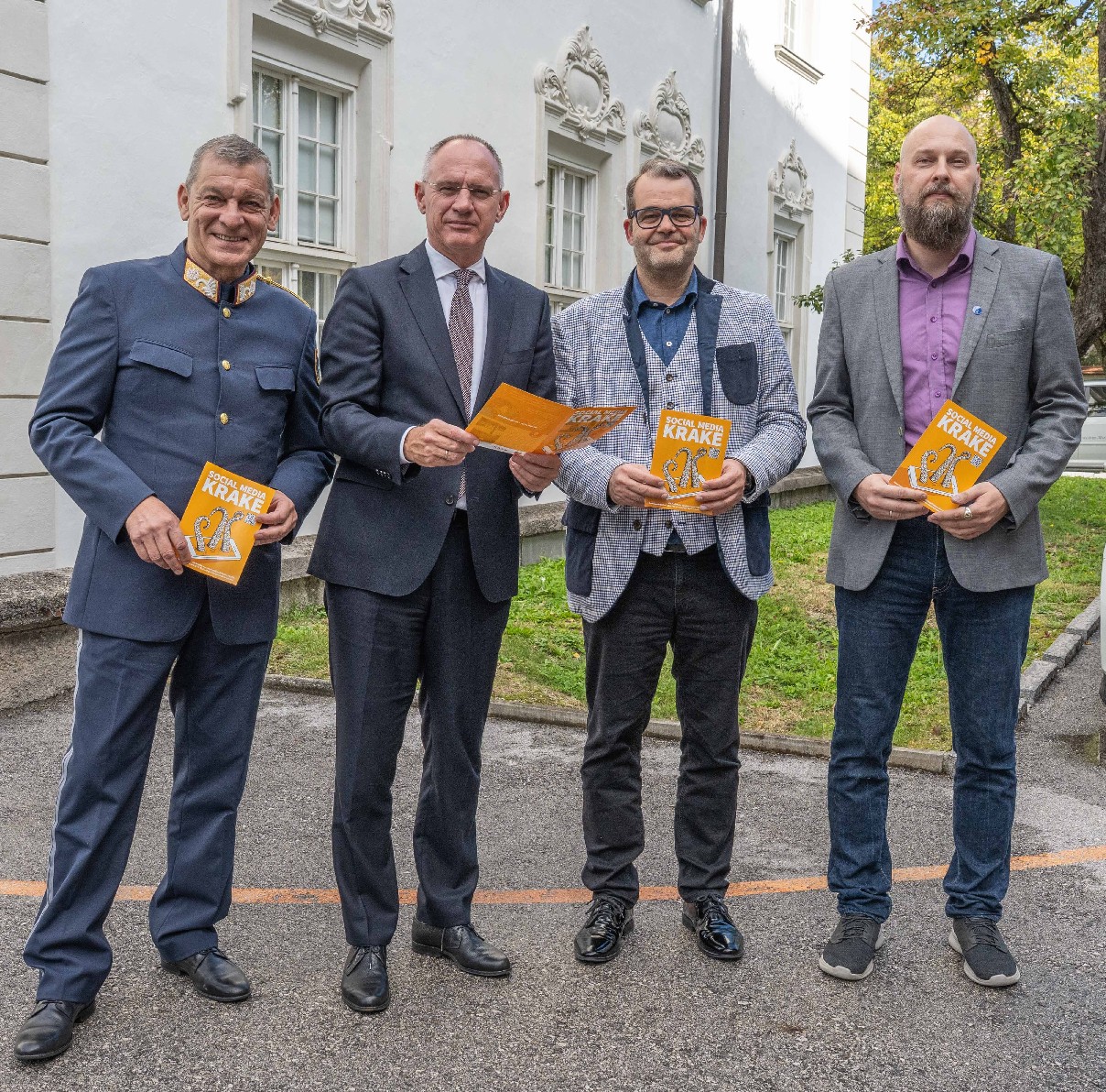 Landespolizeidirektor Helmut Tomac, Innenminister Gerhard Karner, Schuldirektor Michael Griesser und Präventionsbeamter Mario Hechenblaickner mit der Präventionsbroschüre „SOCIAL MEDIA KRAKE“ bei der Ferrarischule in Innsbruck © LPD Tirol