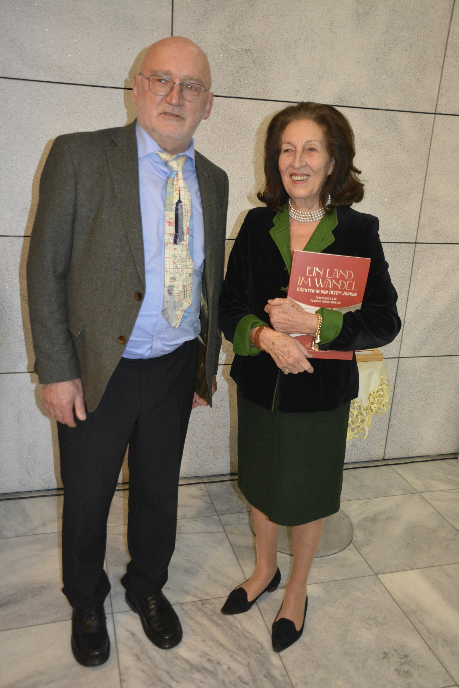 Geschichtsvereins-Direktor Wilhelm Wadl übergab die Festschrift an seine Vorgängerin Claudia Fräss-Ehrfeld. (© Friedrich Hössl/Geschichtsverein)